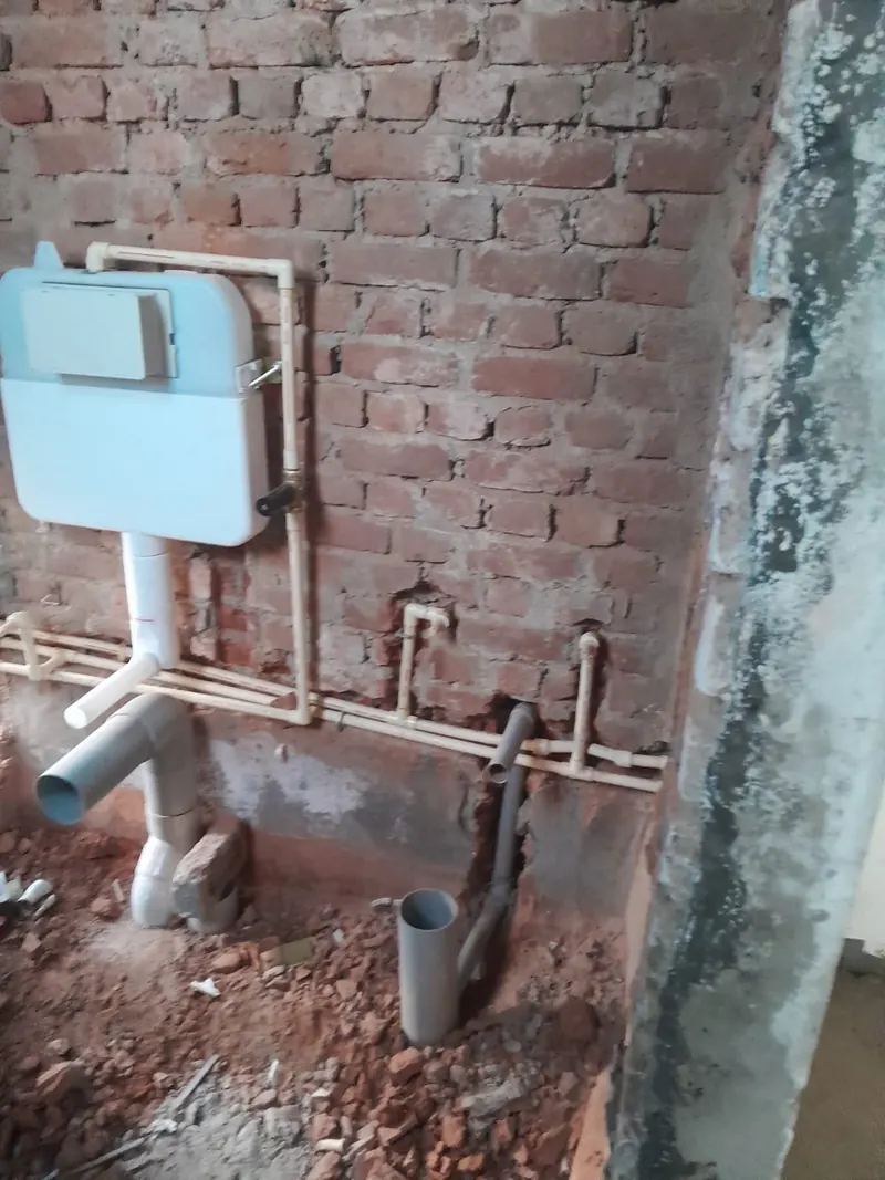 Concealed plumbing lines and cistern installed in brick wall