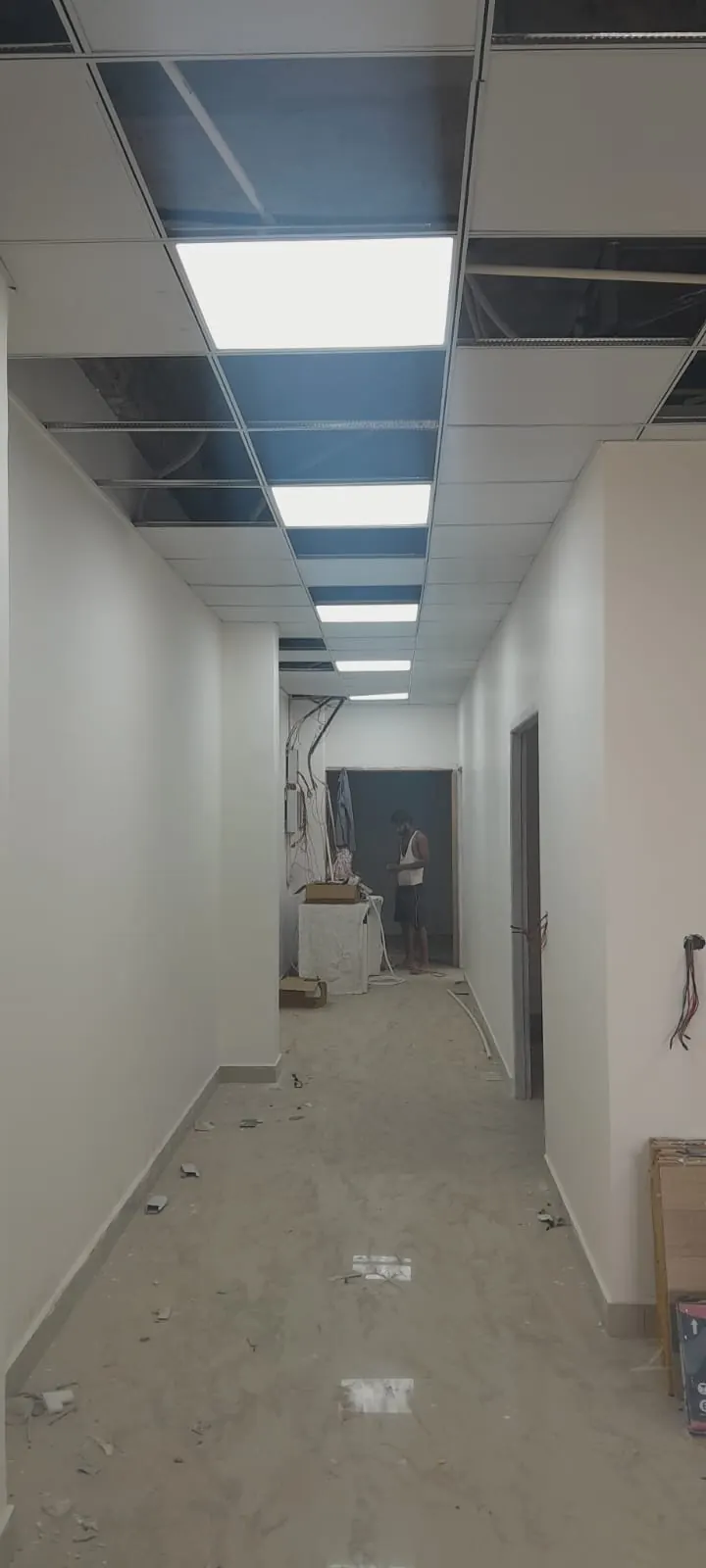Long hospital corridor with glossy flooring and false ceiling
