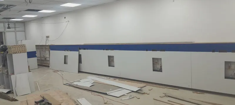 Hospital wall cladding with bed-head service panels under installation