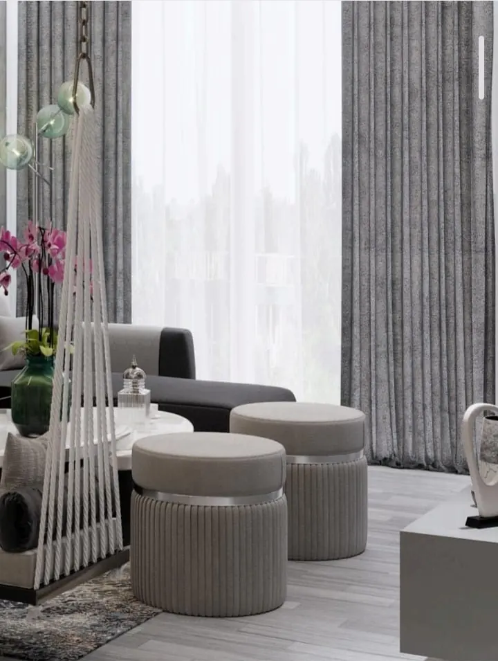 Lounge corner interior with upholstered poufs and sheer curtains