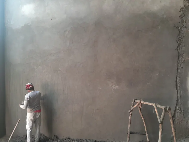 Mason finishing a large plastered wall