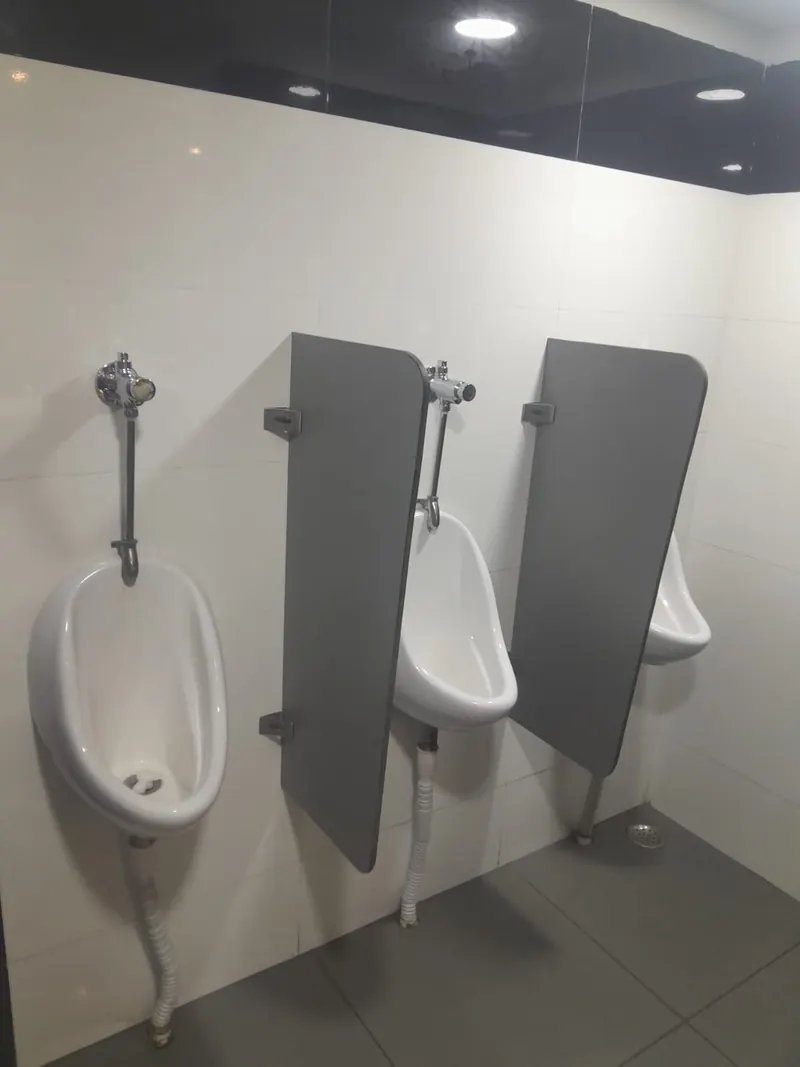 Commercial washroom with urinal partitions and tiled flooring